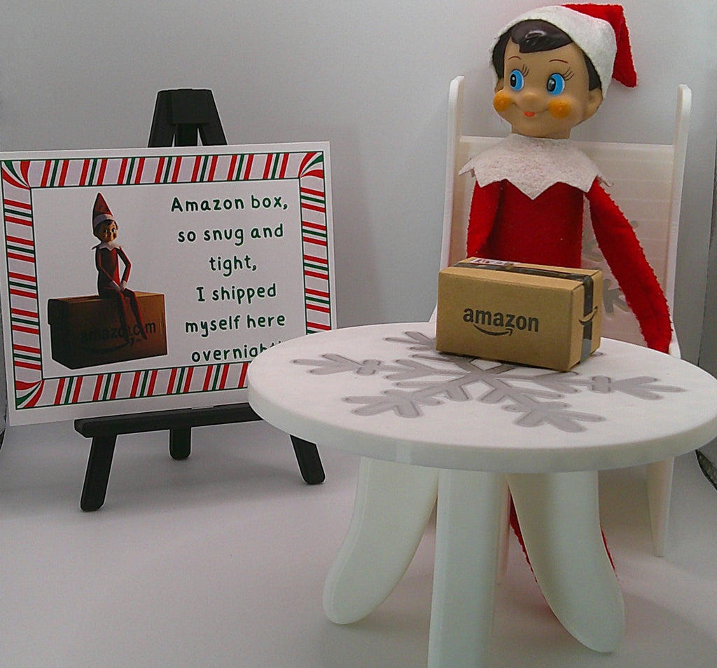 Elf on the Shelf with an Amazon box and a sign in the background