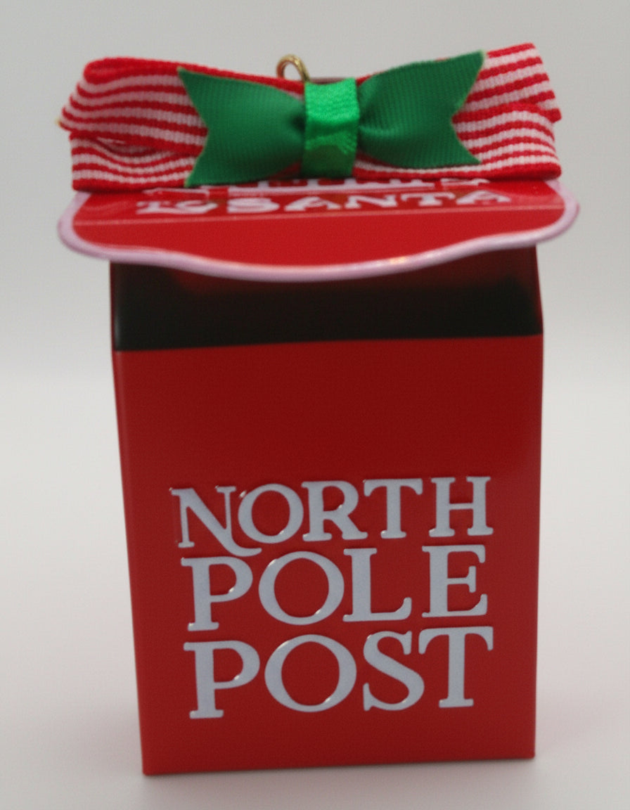 Red mailbox ornament with 'North Pole Post' text and candy cane bow on a white background