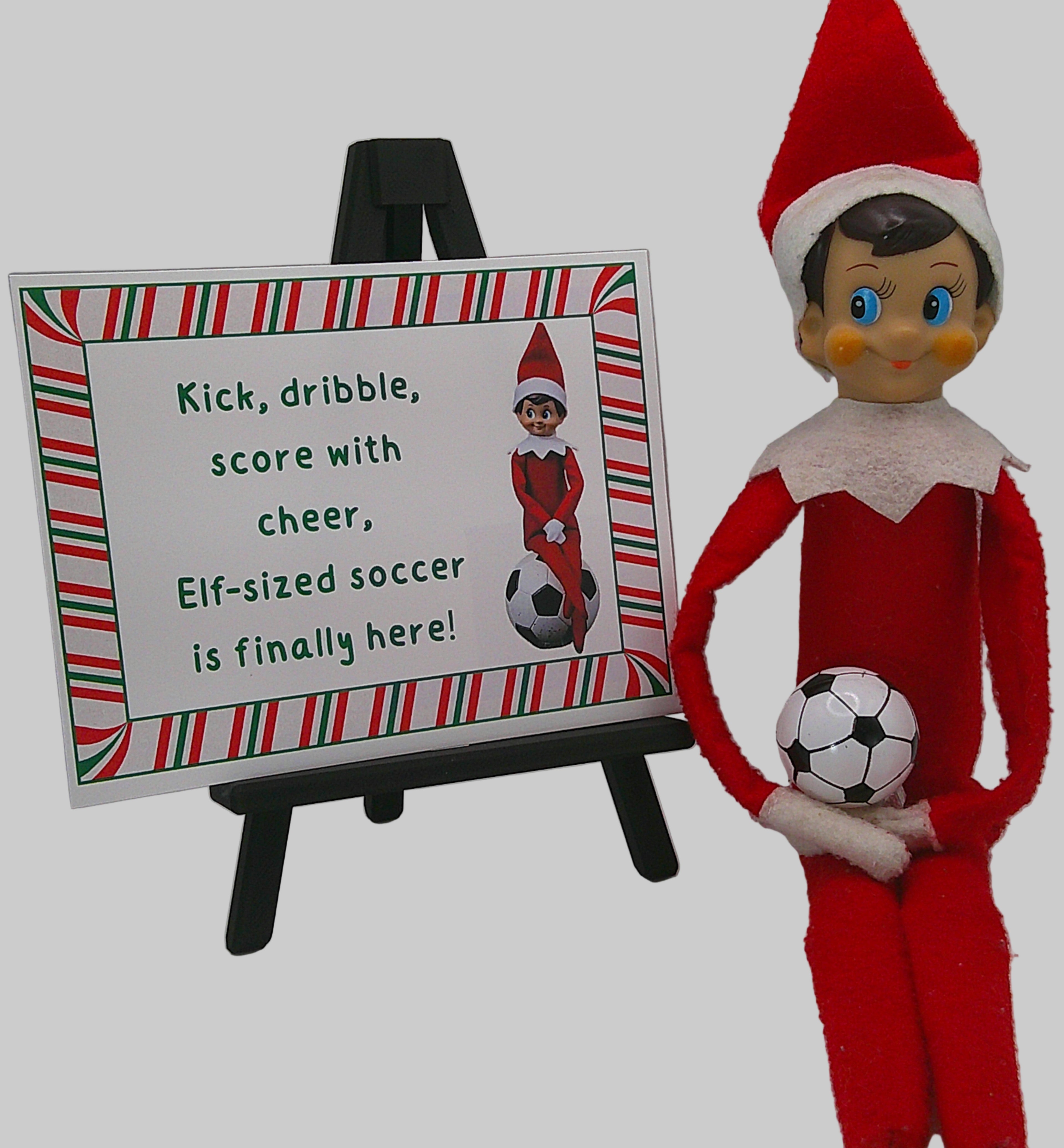 Elf on the Shelf holding a soccer ball next to a sign about Elf-sized soccer