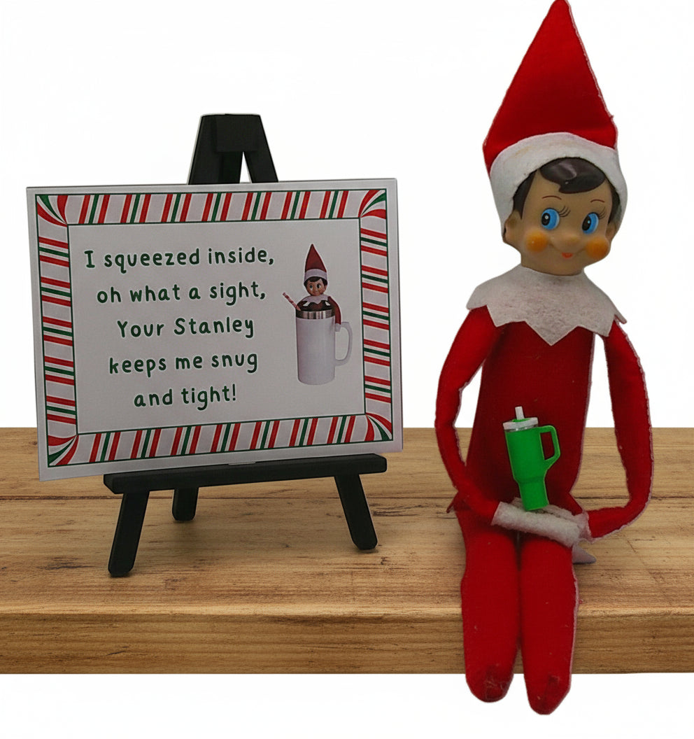 Elf on the Shelf with a mug and a sign next to it on a white background